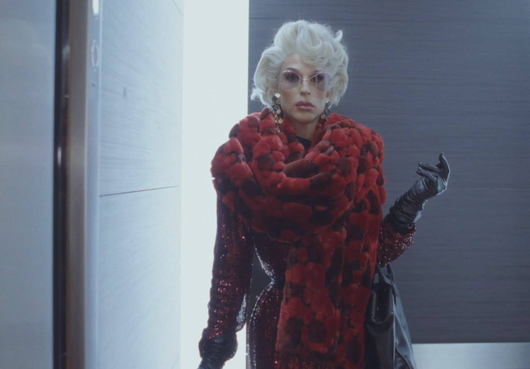 A performer in a red fur coat in a film scene