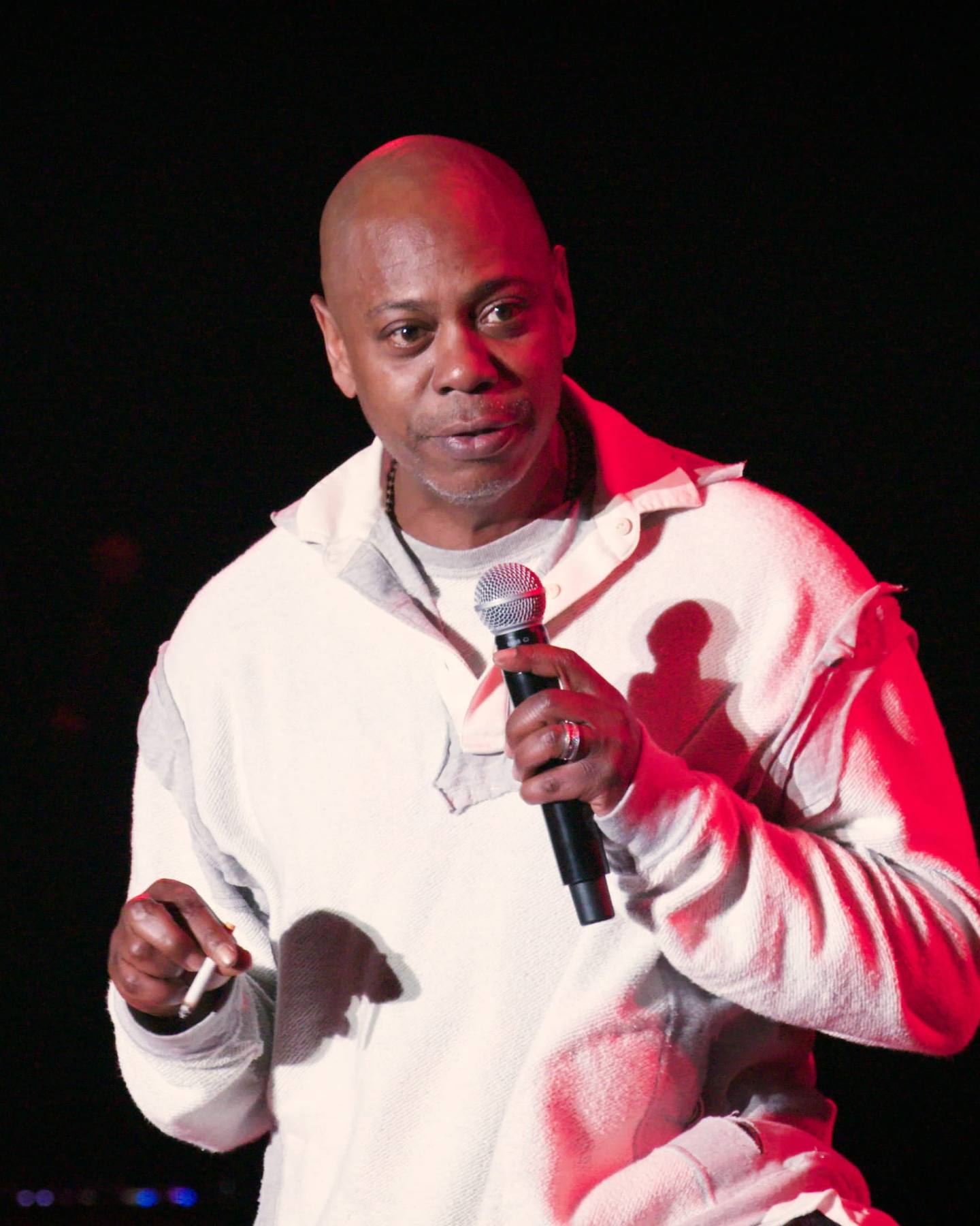 A comedian performing on stage with a microphone