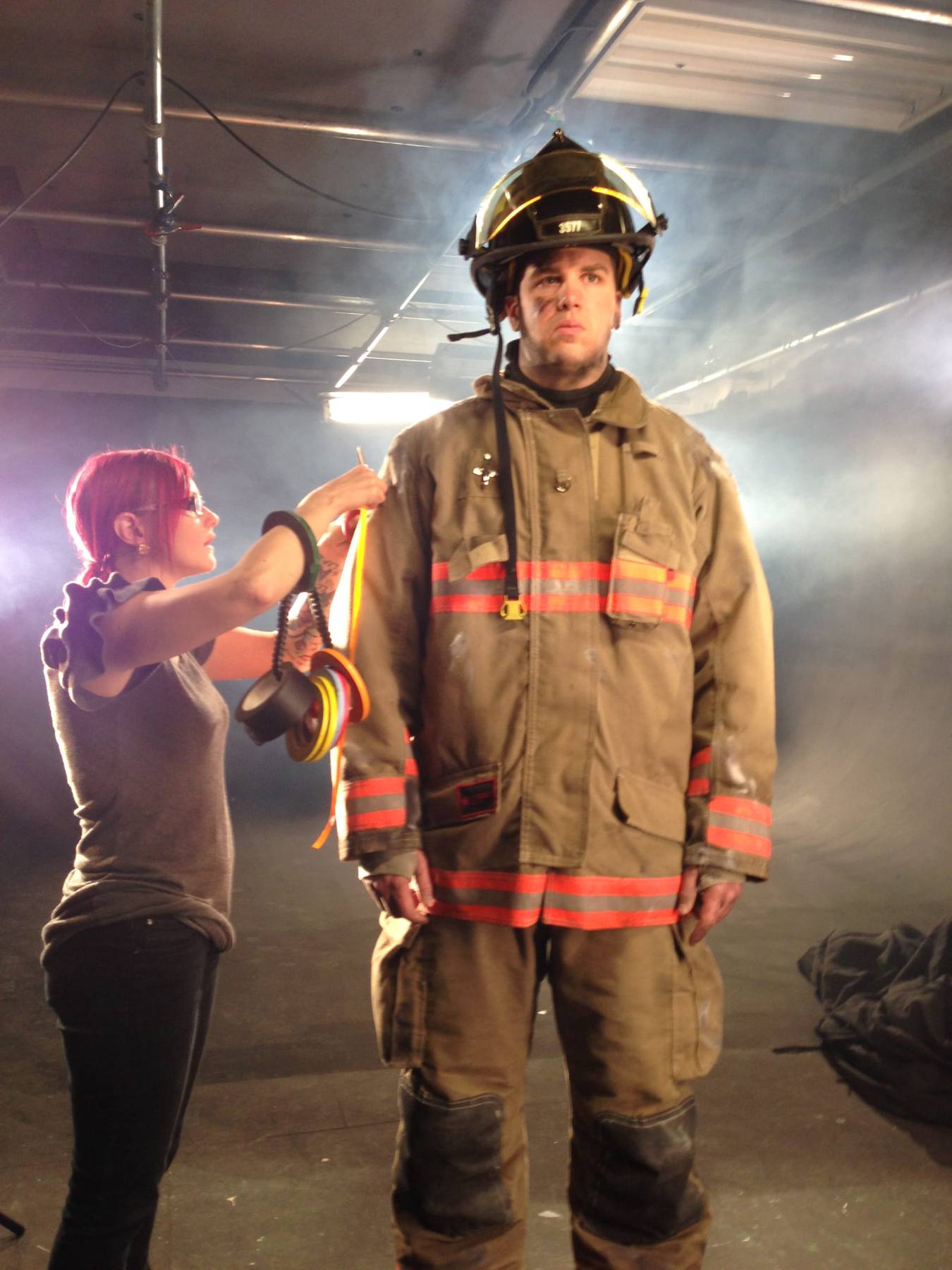 Wardrobe fitting for a firefighter on a smoky film set