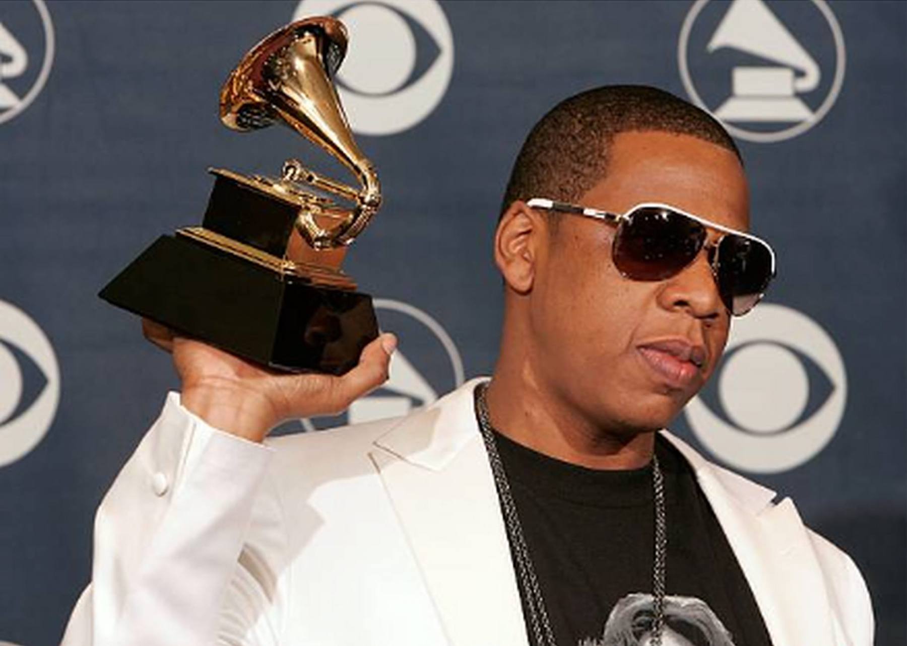 An artist holding a Grammy award backstage